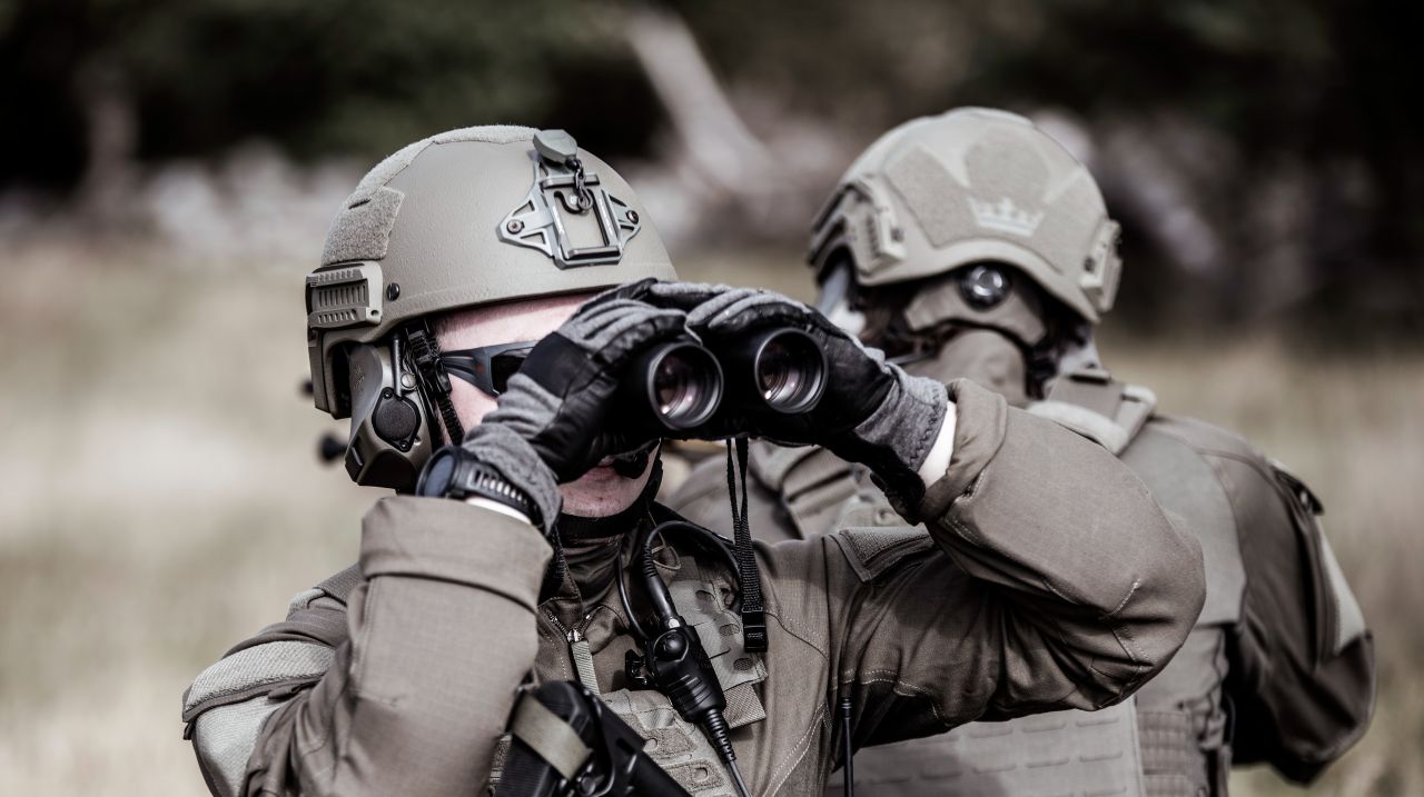 Fighters with active headsets and binoculars at the training ground
