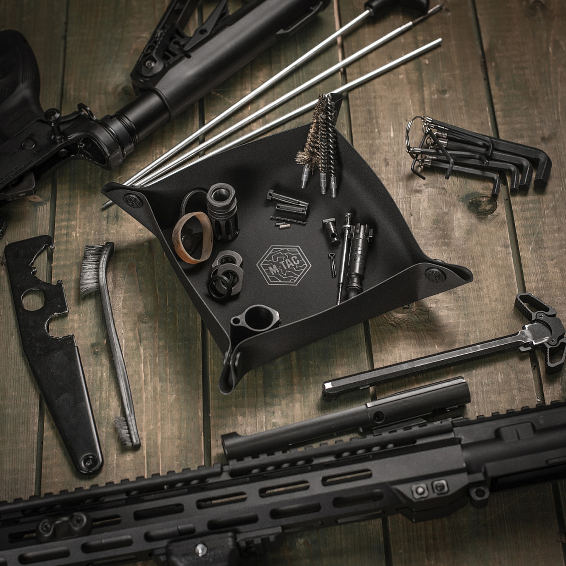 A tray with weapon parts and cleaning tools next to