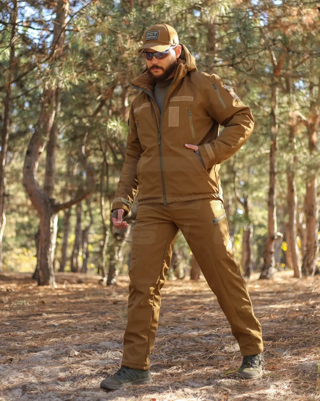 A man in coyote-colored tactical clothing in the forest