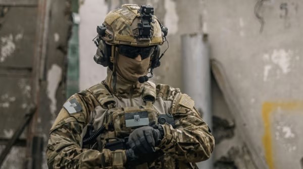 A modern Ukrainian Armed Forces soldier in full gear against a backdrop of buildings