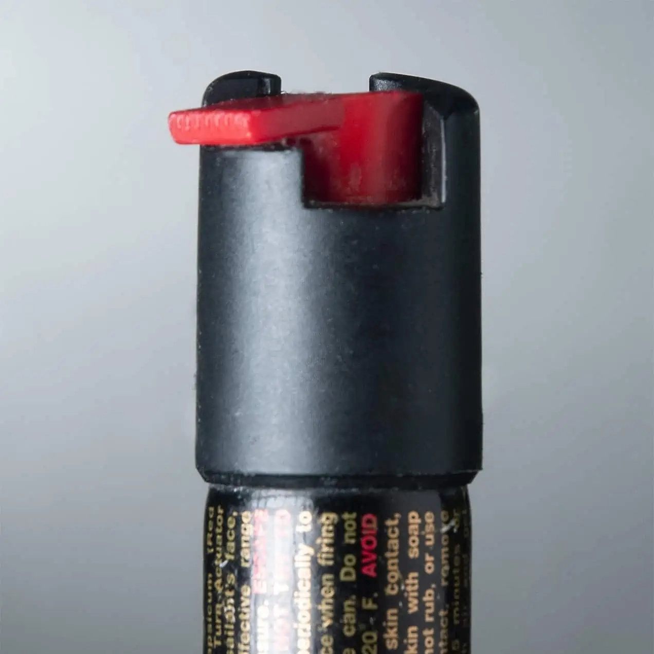 Close-up of a pepper spray cap with a red safety mechanism