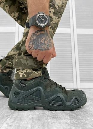 A soldier is lacing up his tactical sneakers