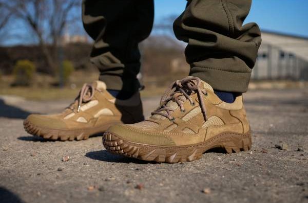 A man in tactical sneakers is standing on the pavement