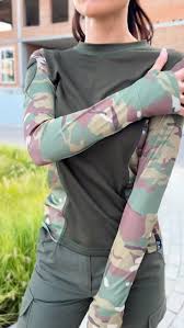 A woman in a solid-colored long-sleeve top with camouflage sides and sleeves
