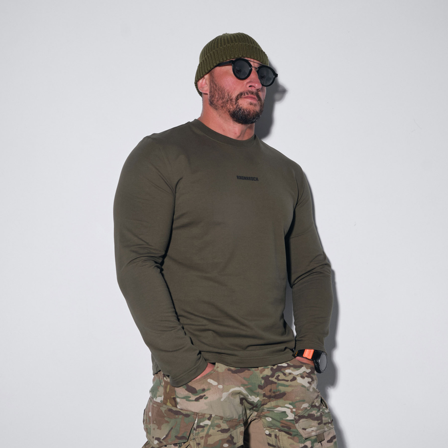 A long-sleeve shirt on a burly man with stubble, wearing a beanie and sunglasses