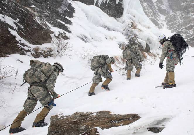 A group of soldiers climbs a snowy mountainside