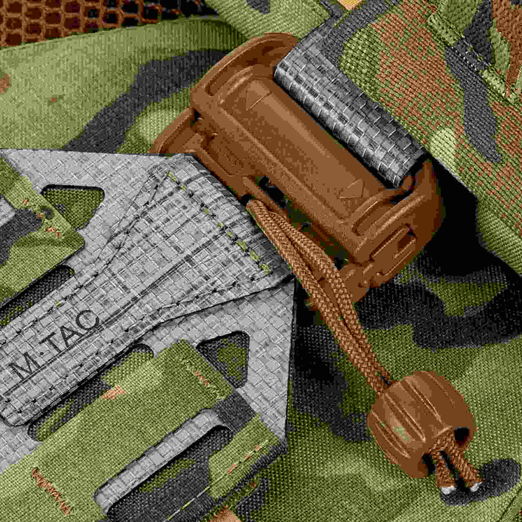 Macro shot of tactical gear with paracord on camouflage fabric