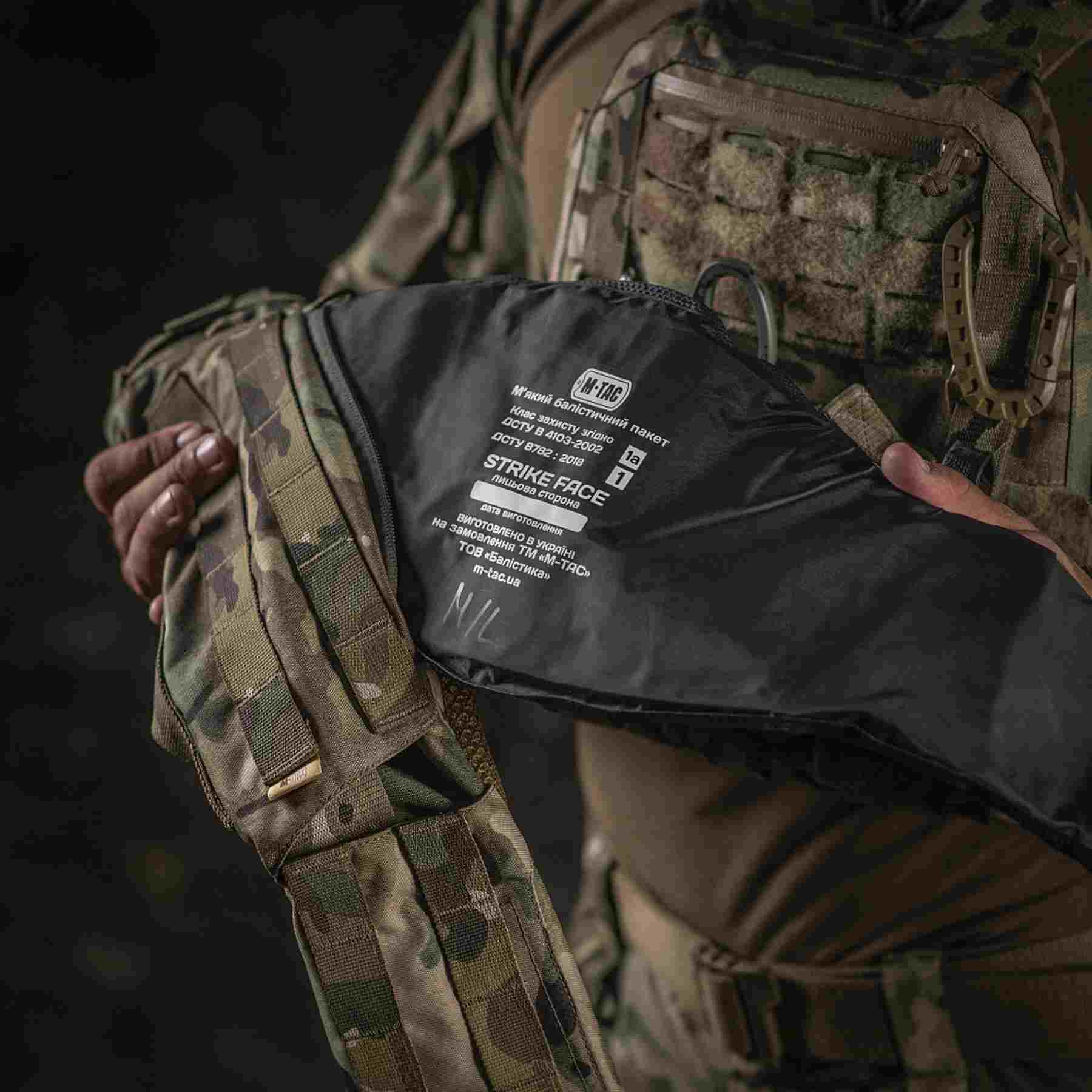 A person inserts a soft ballistic insert into a battle belt